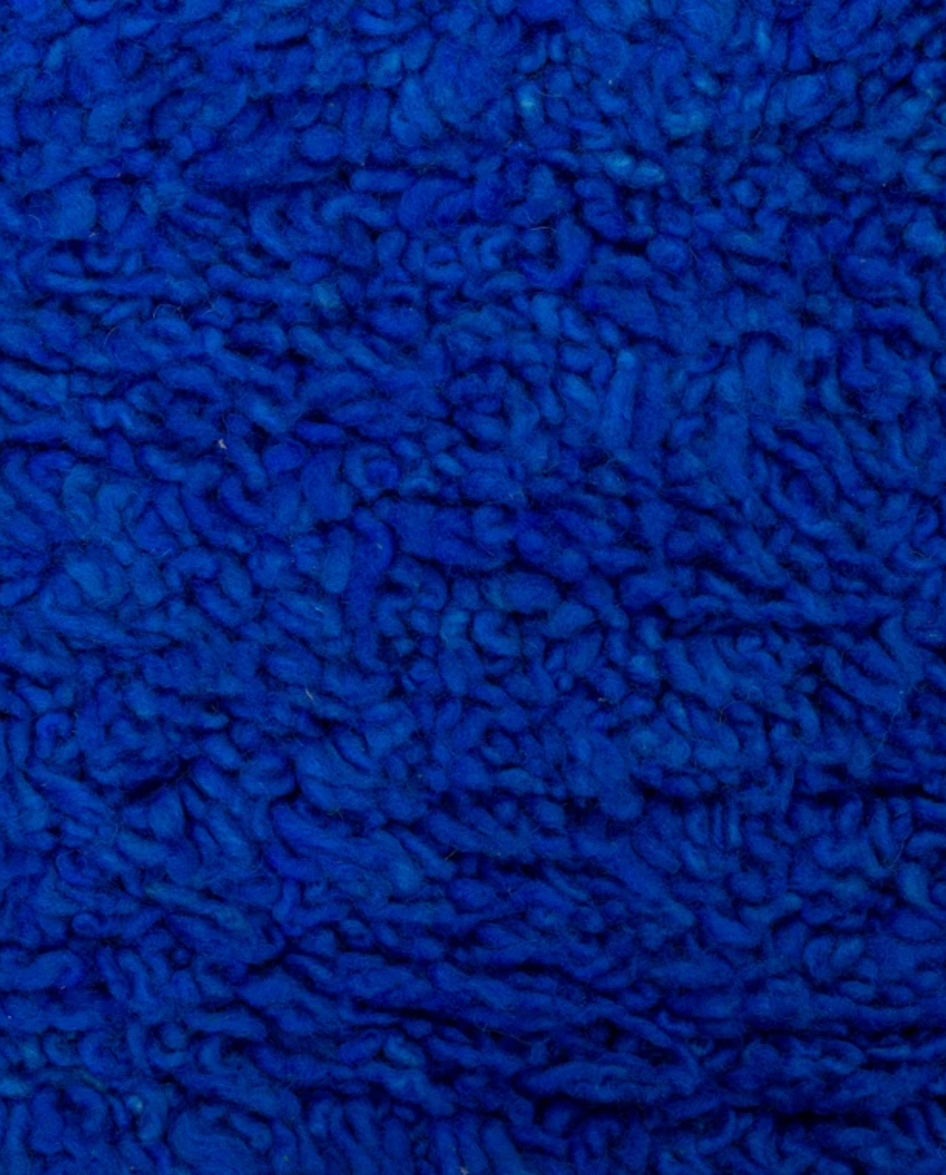 RAJA Mrirt cobalt solid open field Moroccan rug close-up showing hand-knotted wool texture and pile detail, by NURA