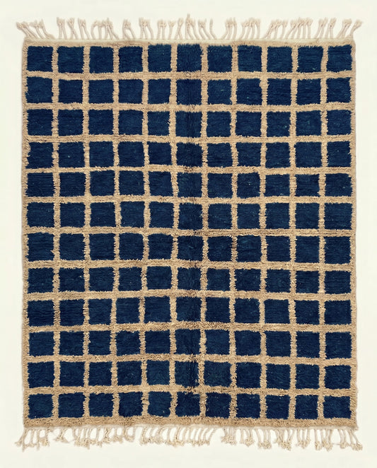 A bold navy checkered Moroccan rug featuring a contrasting beige grid pattern and dense hand-knotted wool pile by NURA.