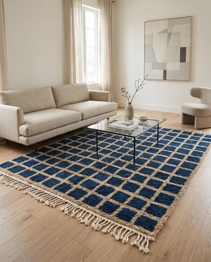 A navy checkered Moroccan rug by NURA styled in a modern living room, adding bold geometric contrast to the space.