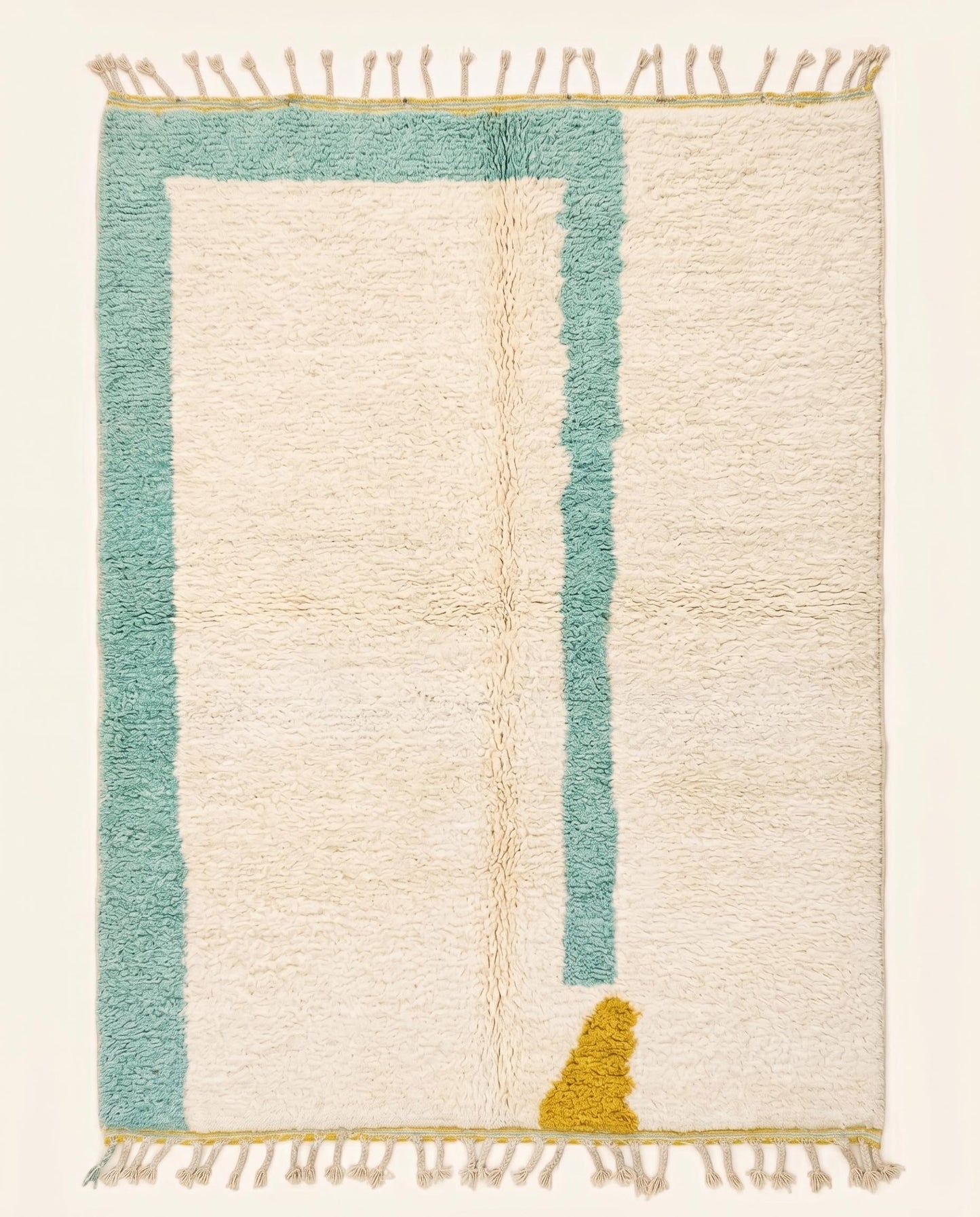 Plush modern Moroccan wool rug featuring a cream open field with an asymmetrical teal border and mustard accent, by NURA.