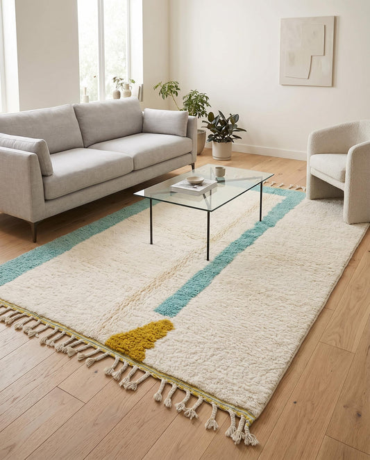 A plush cream and teal modern Moroccan rug by NURA styled in a bright contemporary living room with minimalist furniture.