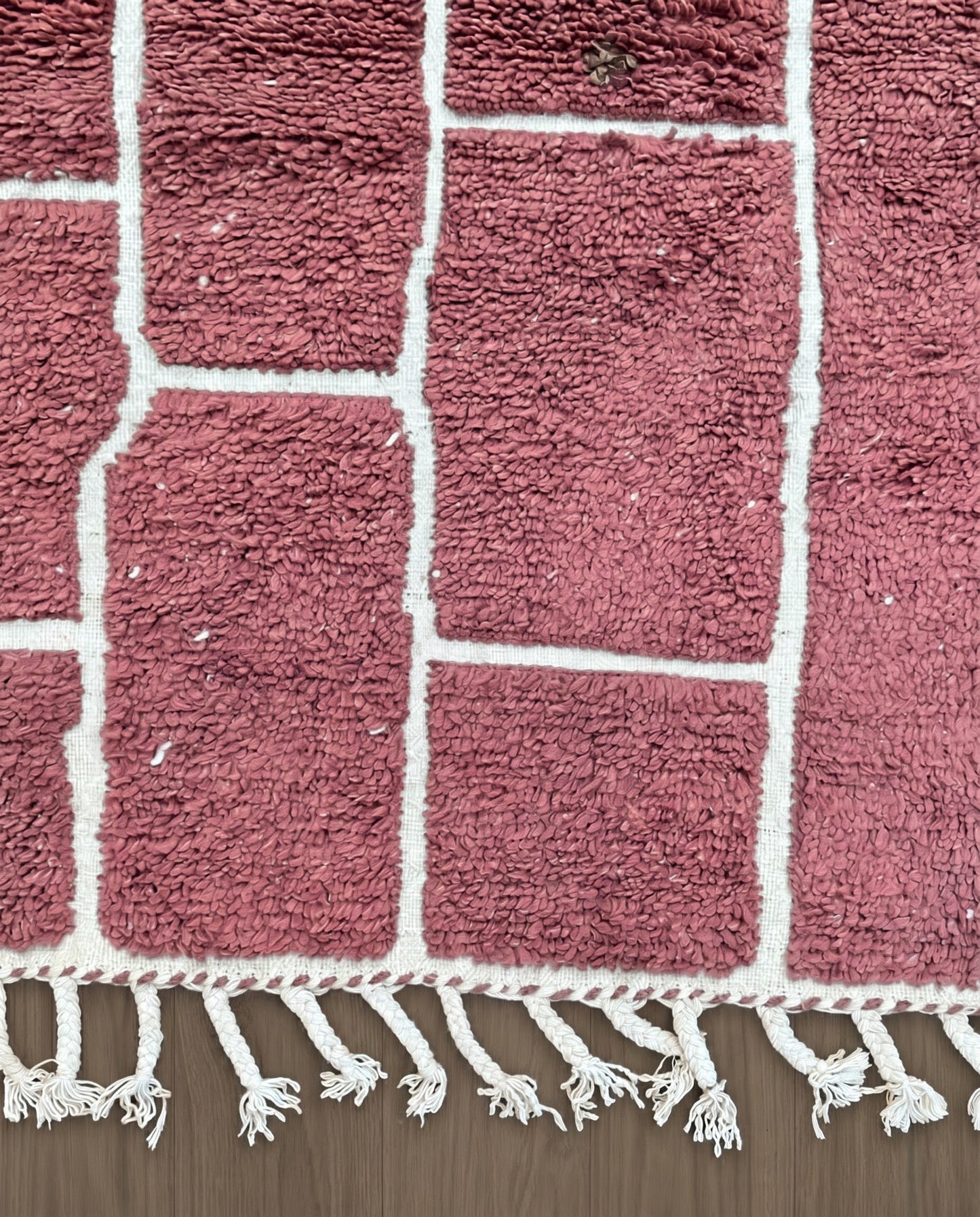 RAZANE Beni Ourain dusty rose irregular block grid Moroccan rug close-up of hand-tied fringe and kilim band detail, by NURA