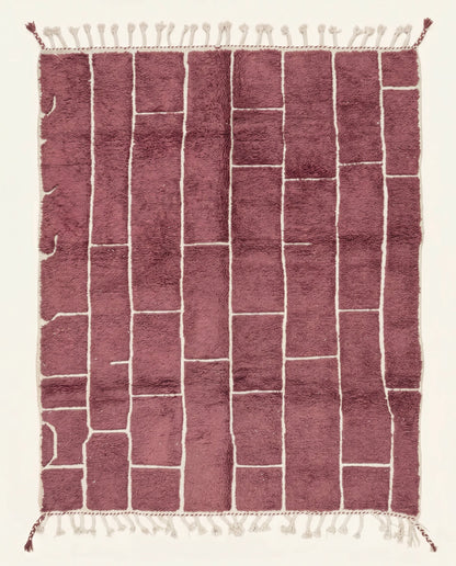 A modern Moroccan rug featuring an irregular block grid in dusty rose with recessed cream lines, showcasing a plush wool pile by NURA.