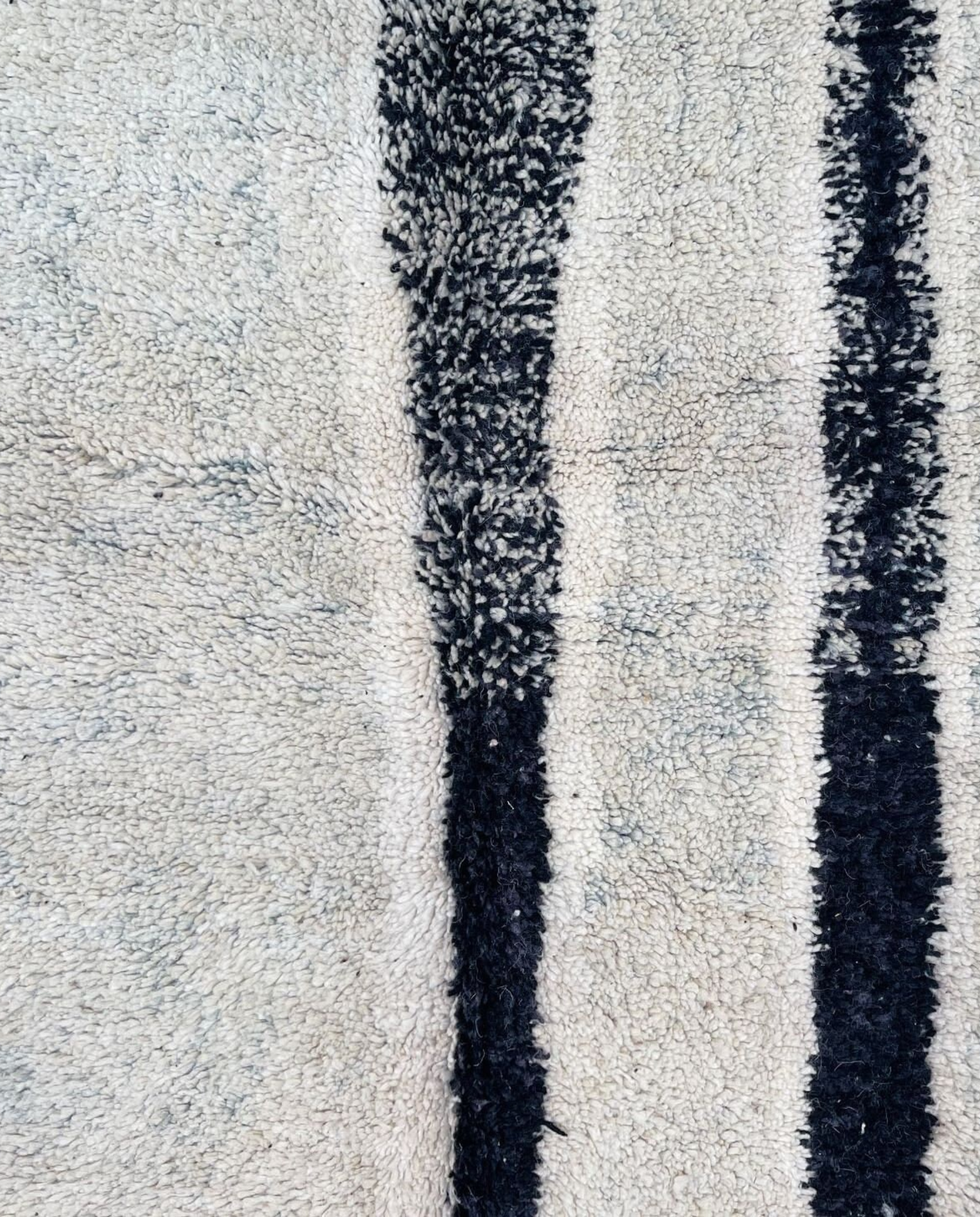 RIHAB Beni Ourain ivory irregular striped field Moroccan rug close-up showing hand-knotted wool texture and pile detail 1, by NURA