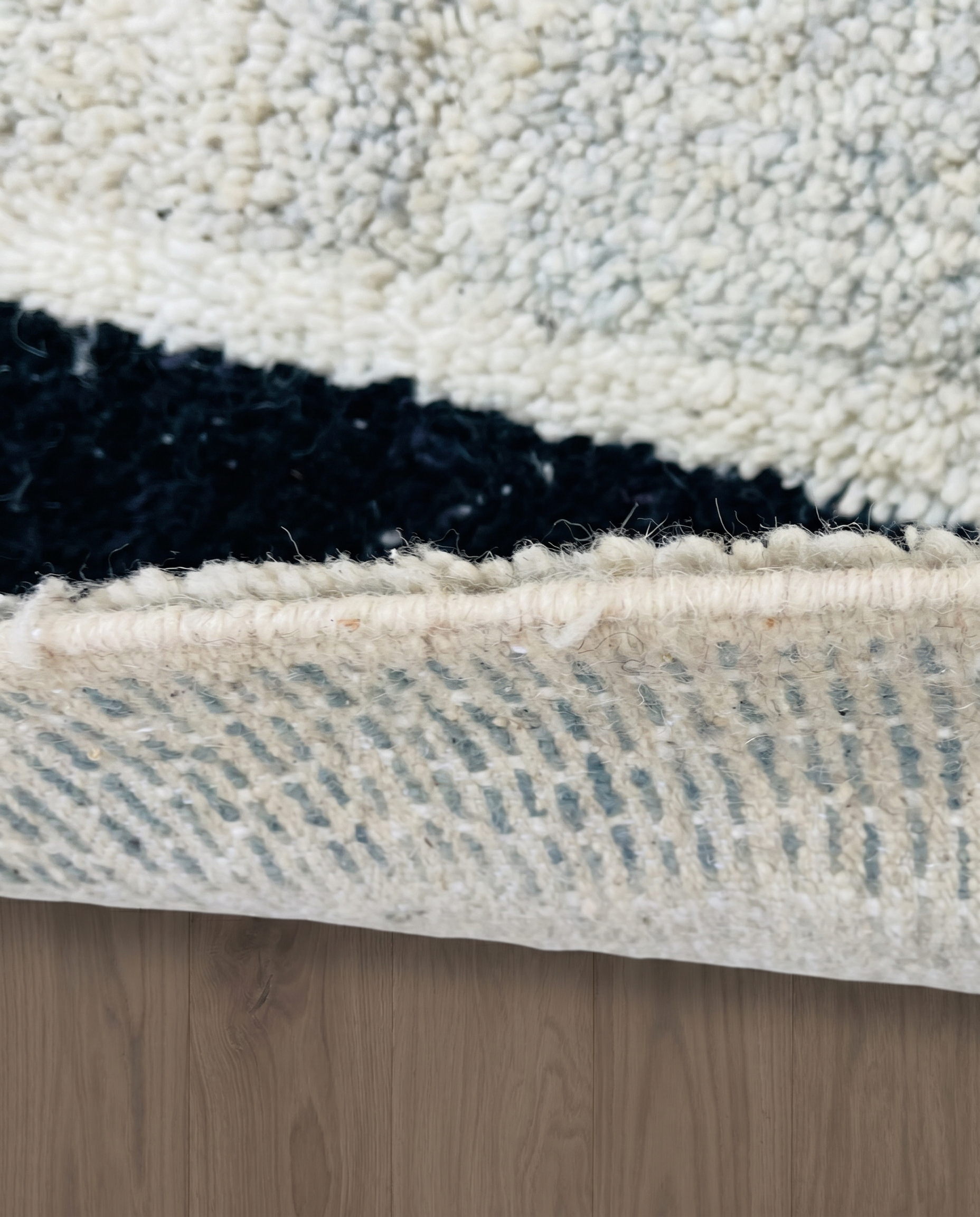 RIHAB Beni Ourain ivory irregular striped field Moroccan rug close-up showing hand-knotted wool texture and pile detail 2, by NURA