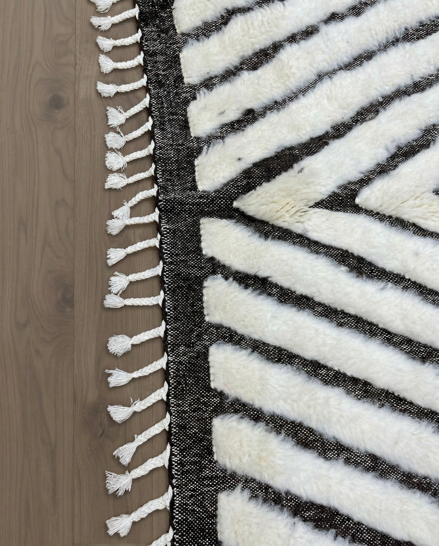 RIM Beni Ourain charcoal concentric diamond Moroccan rug close-up of hand-tied fringe and kilim band detail, by NURA