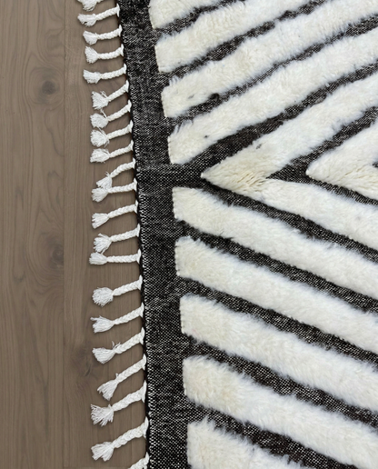 RIM Beni Ourain charcoal concentric diamond Moroccan rug close-up of hand-tied fringe and kilim band detail, by NURA