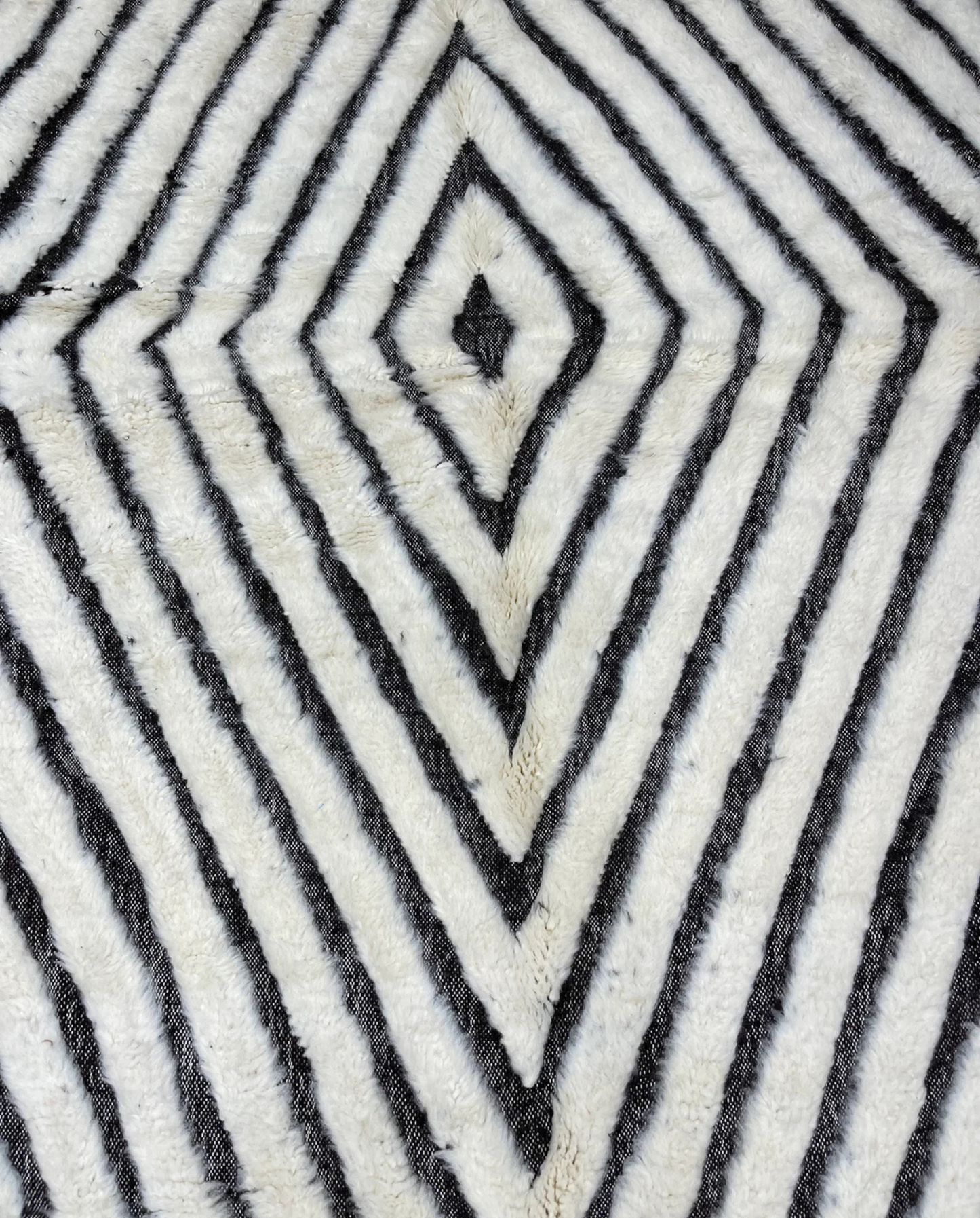 RIM Beni Ourain charcoal concentric diamond Moroccan rug close-up showing hand-knotted wool texture and pile detail, by NURA