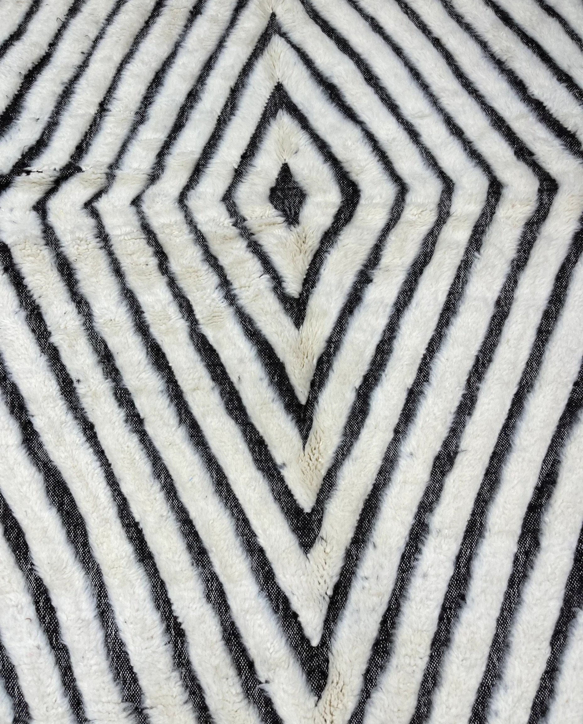 RIM Beni Ourain charcoal concentric diamond Moroccan rug close-up showing hand-knotted wool texture and pile detail, by NURA