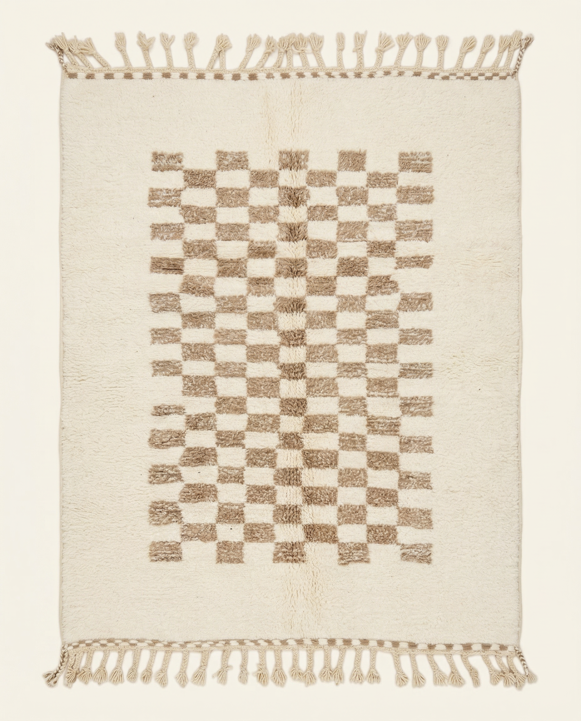 Plush cream Beni Ourain Moroccan rug with a central taupe checkerboard pattern and braided tassels, by NURA.