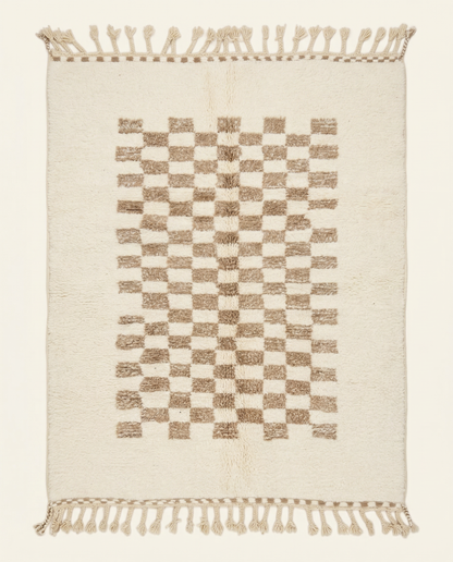 Plush cream Beni Ourain Moroccan rug with a central taupe checkerboard pattern and braided tassels, by NURA.