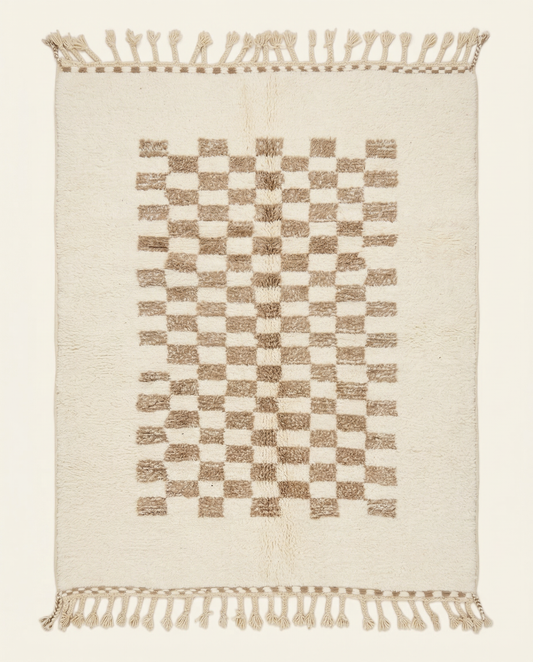 Plush cream Beni Ourain Moroccan rug with a central taupe checkerboard pattern and braided tassels, by NURA.