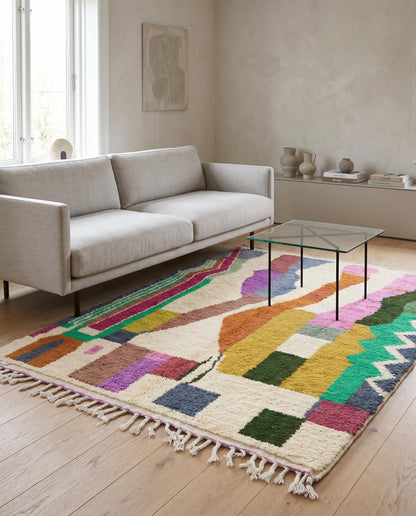 A vibrant abstract Azilal Moroccan rug by NURA styled in a modern living room, adding a bold splash of color to the space.
