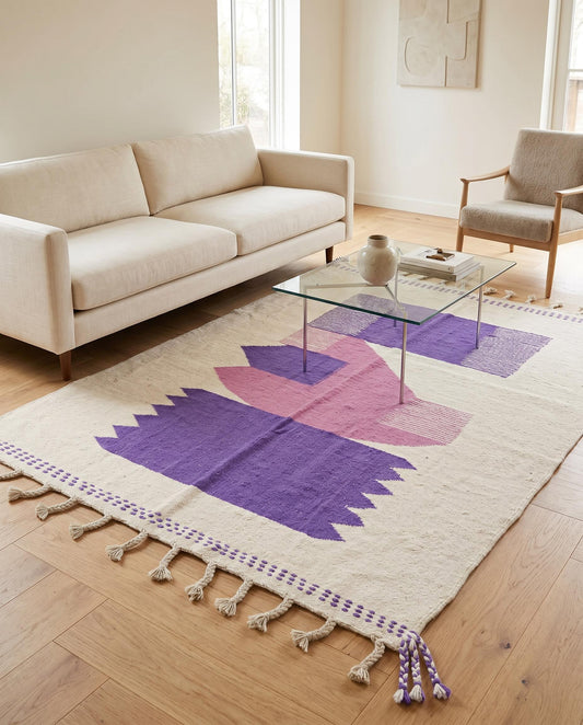 The SADIA Moroccan flatweave rug with purple and pink geometric shapes styled in a bright contemporary living room by NURA.