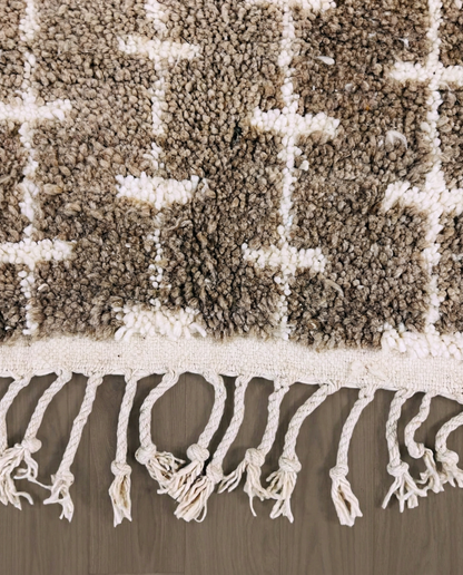 SAFAA Beni Ourain taupe panelled geometric field Moroccan rug close-up of hand-tied fringe and kilim band detail, by NURA