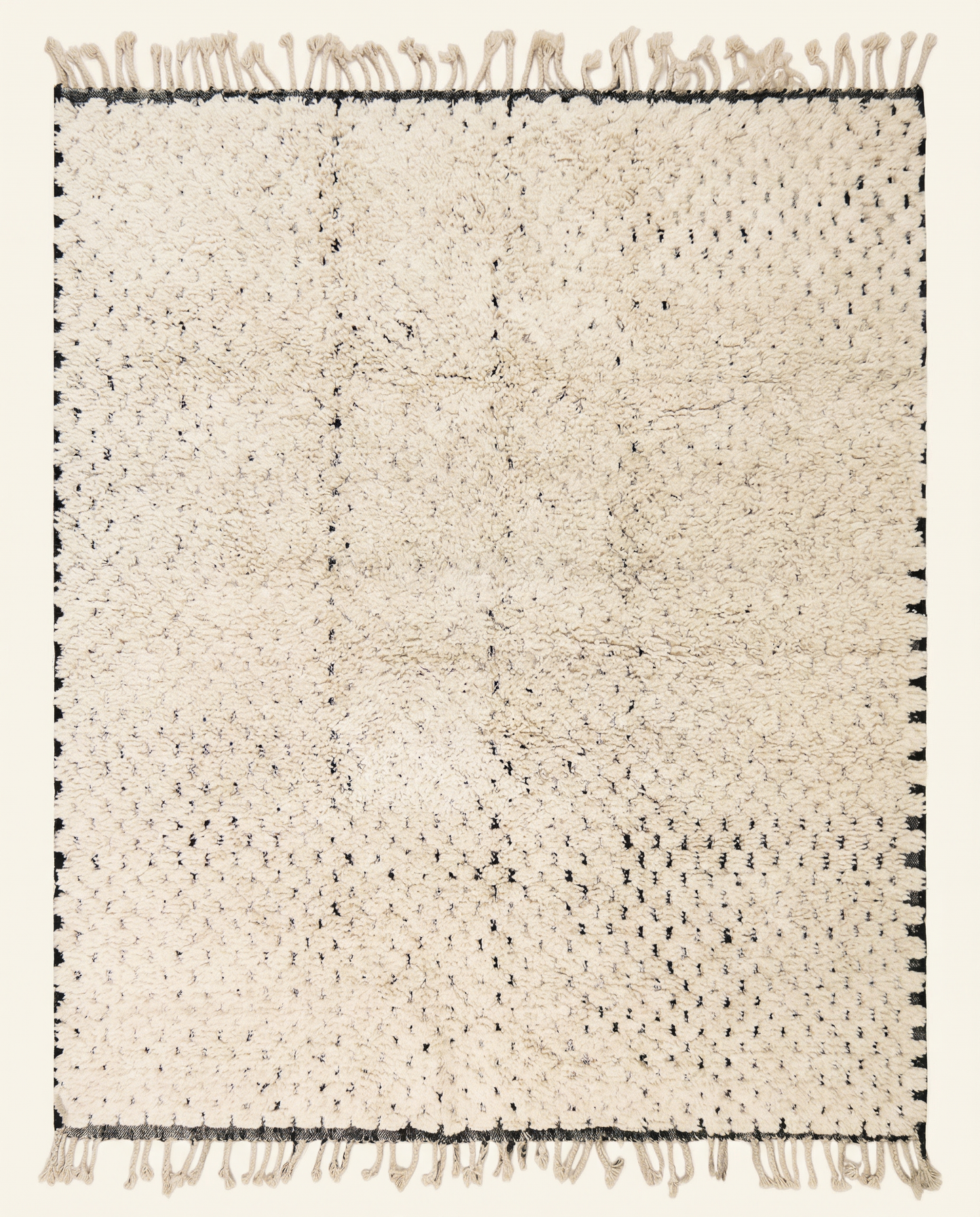 Plush ivory Beni Ourain Moroccan rug with a minimal black dashed line pattern and thick high pile, by NURA.