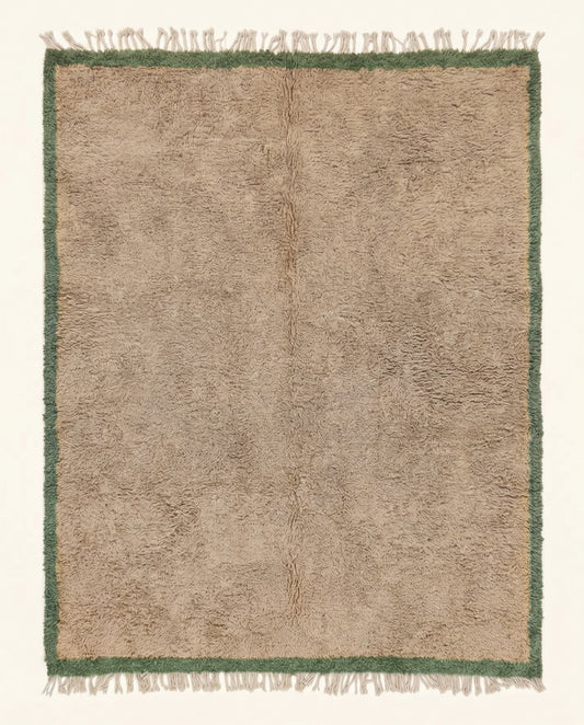 A plush Moroccan wool rug featuring a solid beige field framed by an earthy sage green border, hand-knotted by NURA.