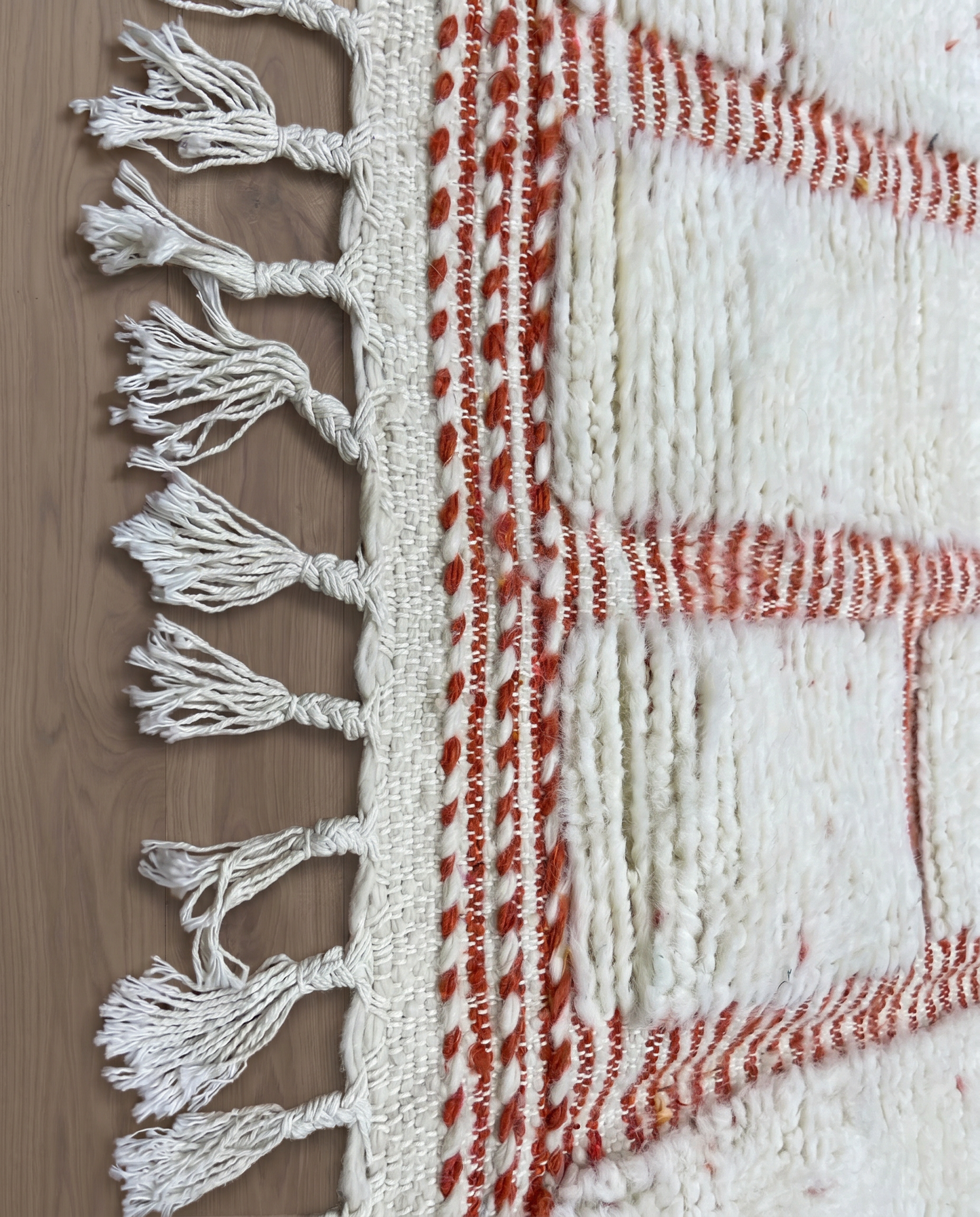SAKINA Beni Ourain ivory textured checker grid Moroccan rug close-up of hand-tied fringe and kilim band detail, by NURA