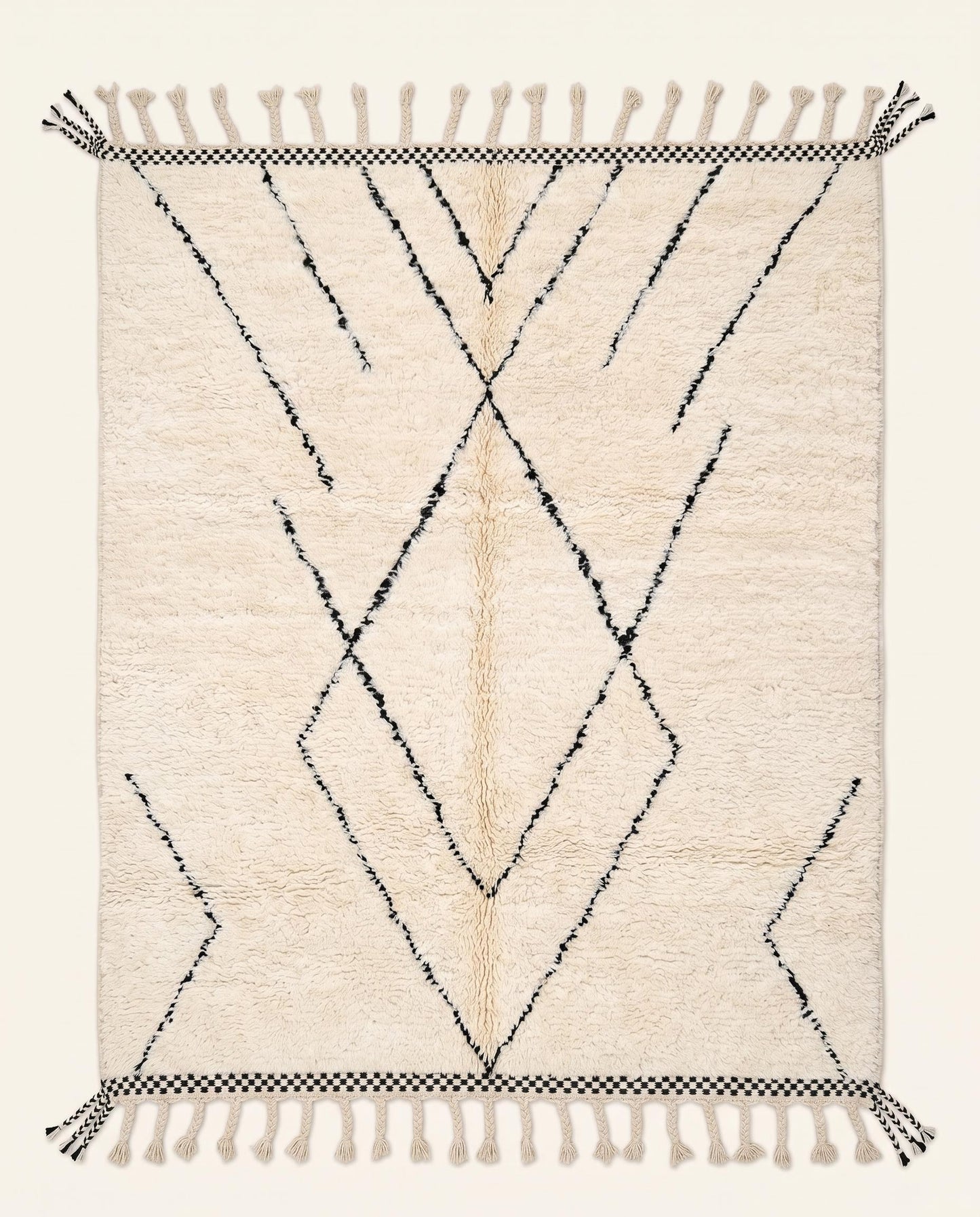 Plush cream Beni Ourain Moroccan rug featuring a minimalist black diamond lattice pattern and checkered ends by NURA.