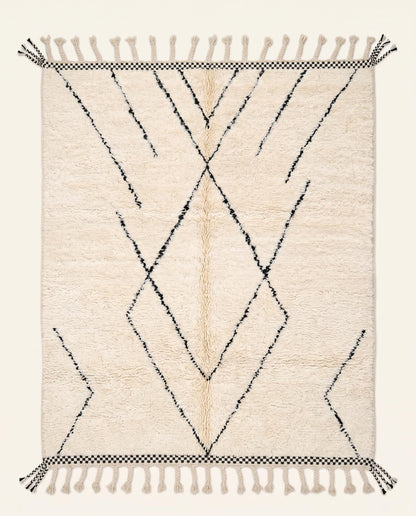 Plush cream Beni Ourain Moroccan rug featuring a minimalist black diamond lattice pattern and checkered ends by NURA.