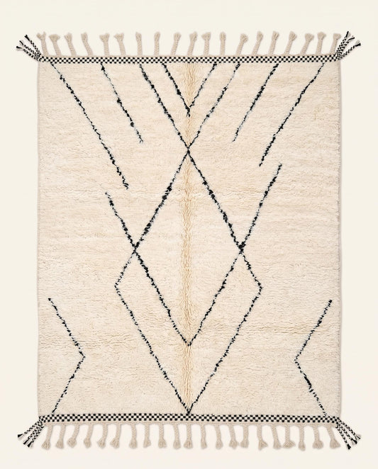 Plush cream Beni Ourain Moroccan rug featuring a minimalist black diamond lattice pattern and checkered ends by NURA.