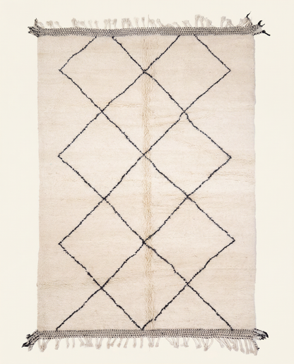Plush ivory Beni Ourain Moroccan rug with a large black diamond lattice and flat-woven end bands, by NURA.