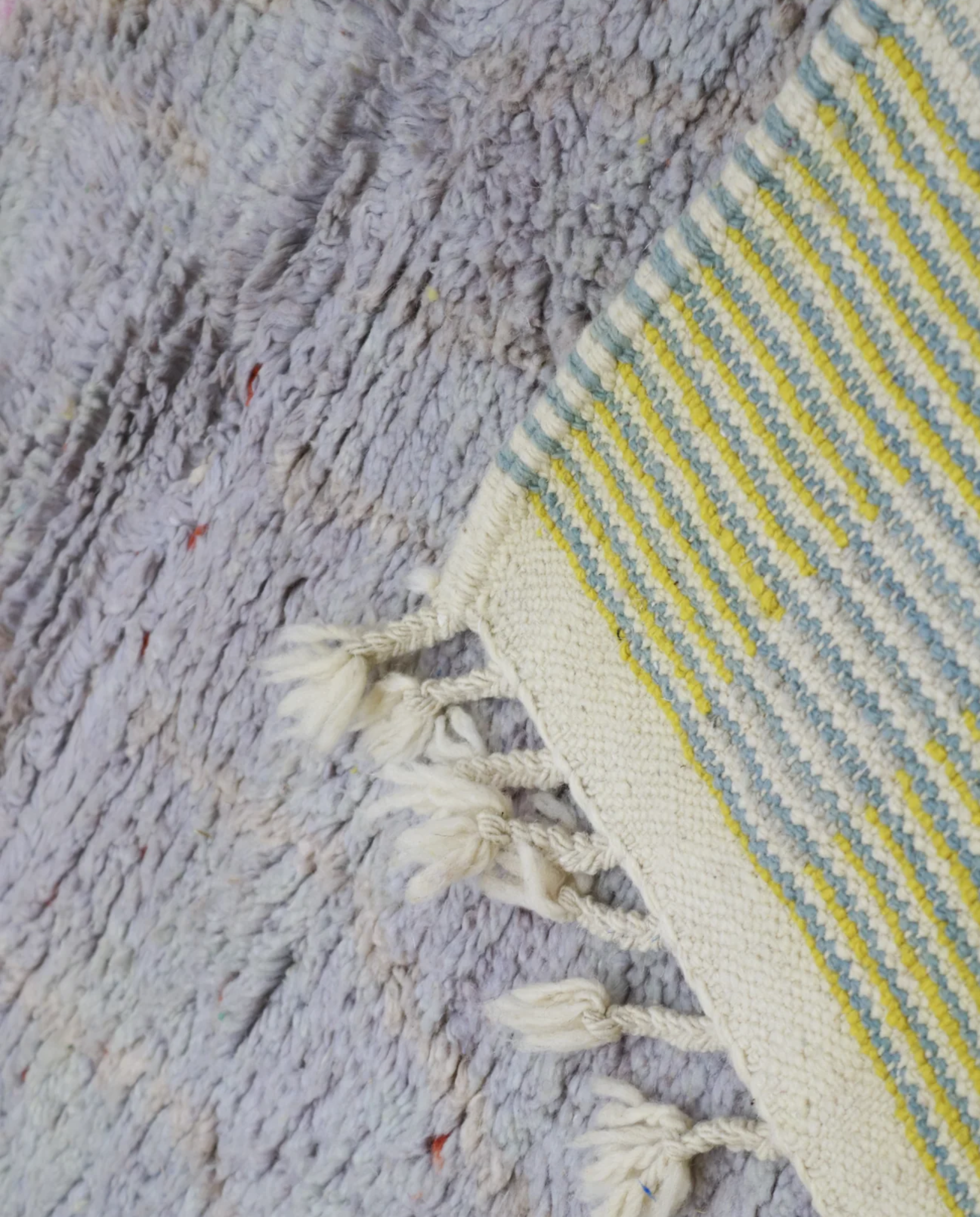 SAMRA Azilal grey color block Moroccan rug close-up of hand-tied fringe and kilim band detail, by NURA
