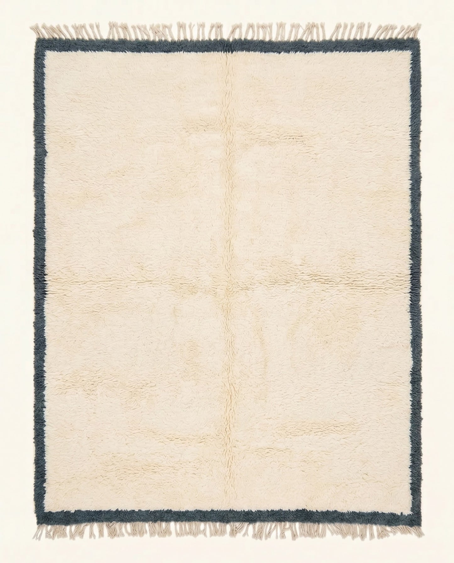 A plush cream Moroccan Beni Ourain rug featuring a thick charcoal border, hand-knotted from soft wool by NURA.