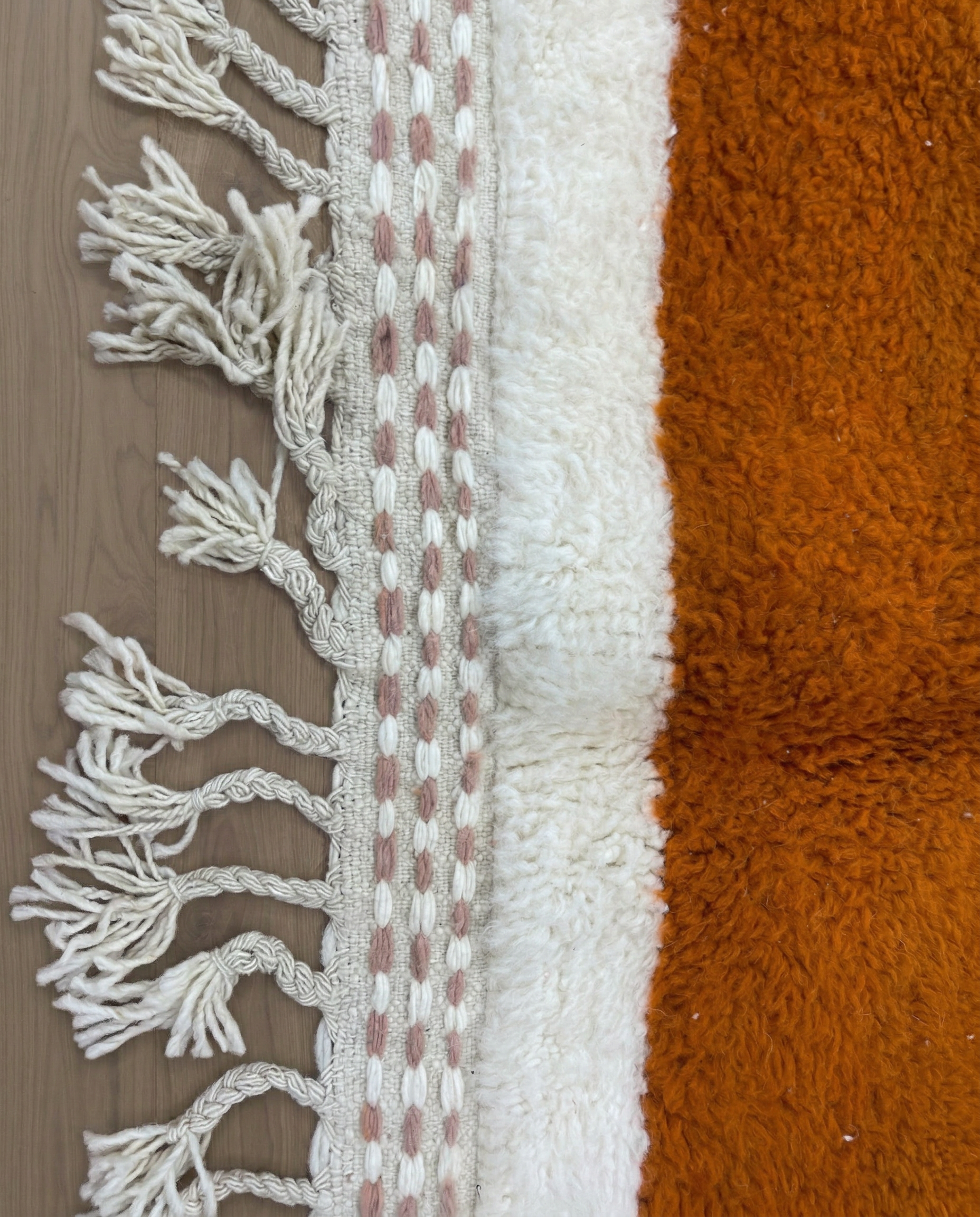 SARA Beni Ourain cream bold hourglass Moroccan rug close-up of hand-tied fringe and kilim band detail, by NURA