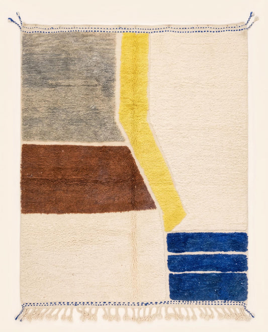 Contemporary abstract Moroccan wool rug featuring bold color blocks of grey, brown, yellow, and blue on a plush cream pile by NURA.