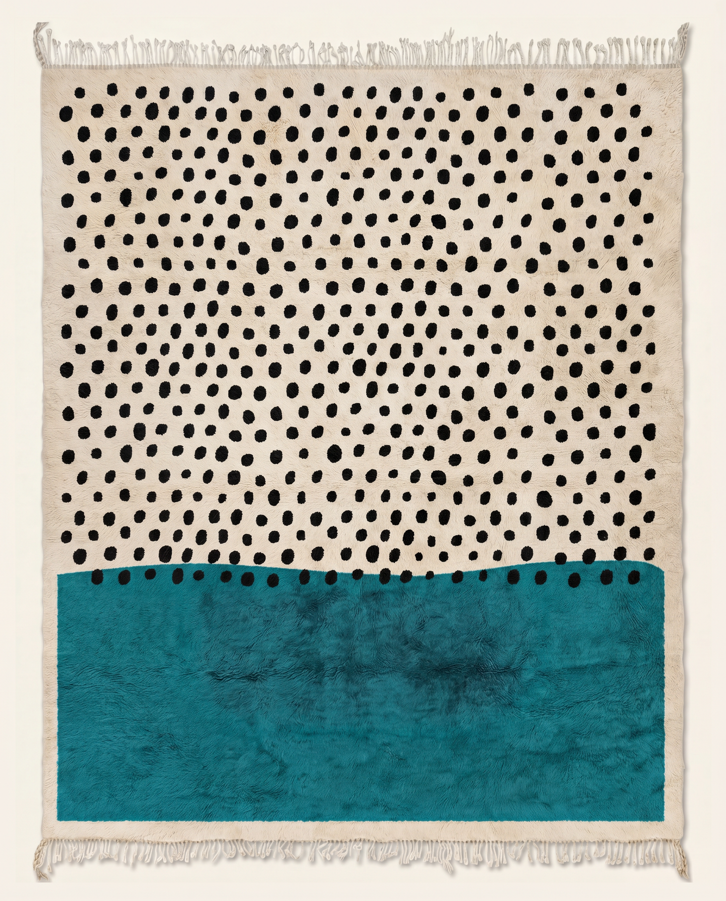A contemporary Moroccan rug featuring black polka dots on a cream wool background with a bold teal color block, by NURA.