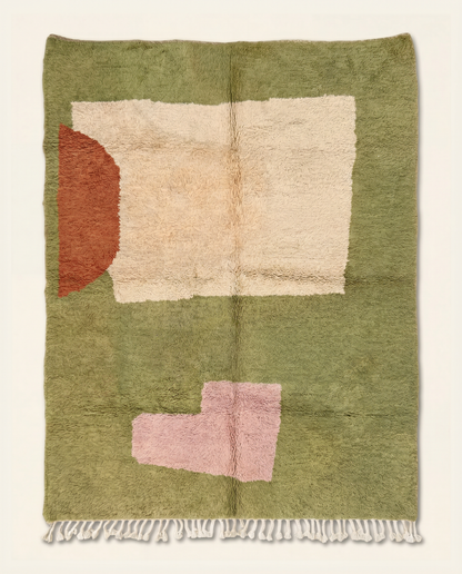 A plush Moroccan wool rug with abstract cream, rust, and blush color blocks on a sage green background by NURA.
