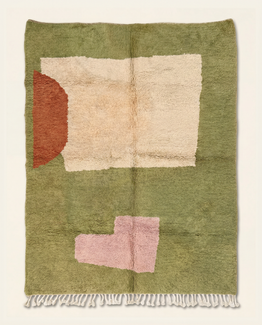 A plush Moroccan wool rug with abstract cream, rust, and blush color blocks on a sage green background by NURA.