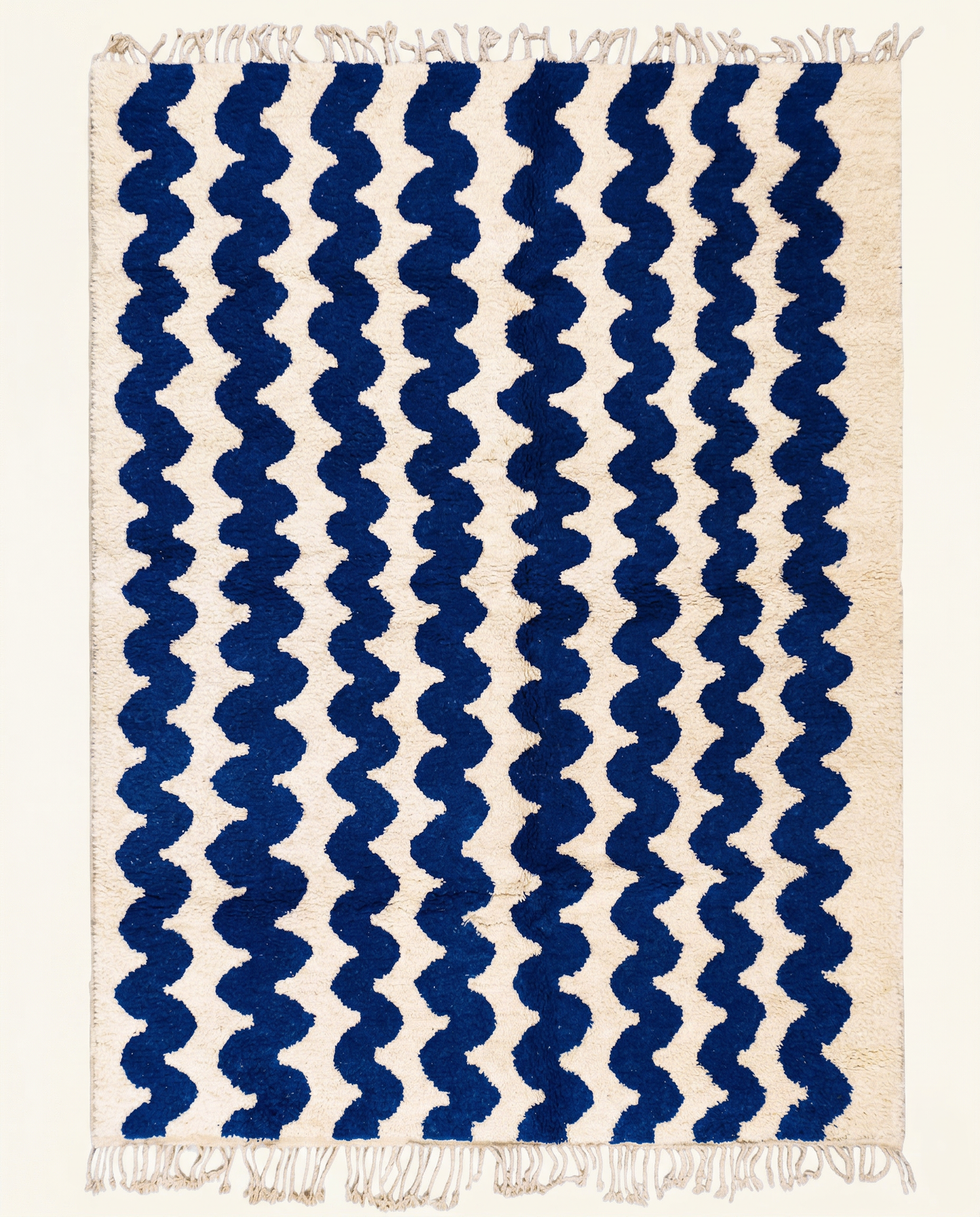 Plush cream Moroccan rug with a bold all-over pattern of wavy cobalt blue horizontal stripes and a thick pile, by NURA.