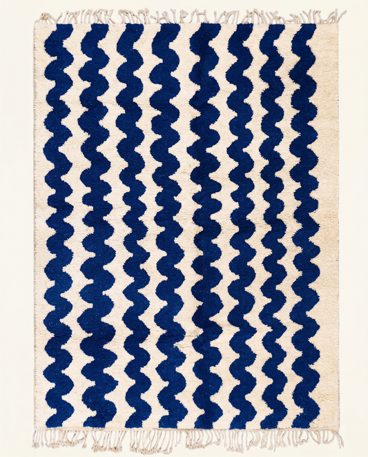 Plush cream Moroccan rug with a bold all-over pattern of wavy cobalt blue horizontal stripes and a thick pile, by NURA.