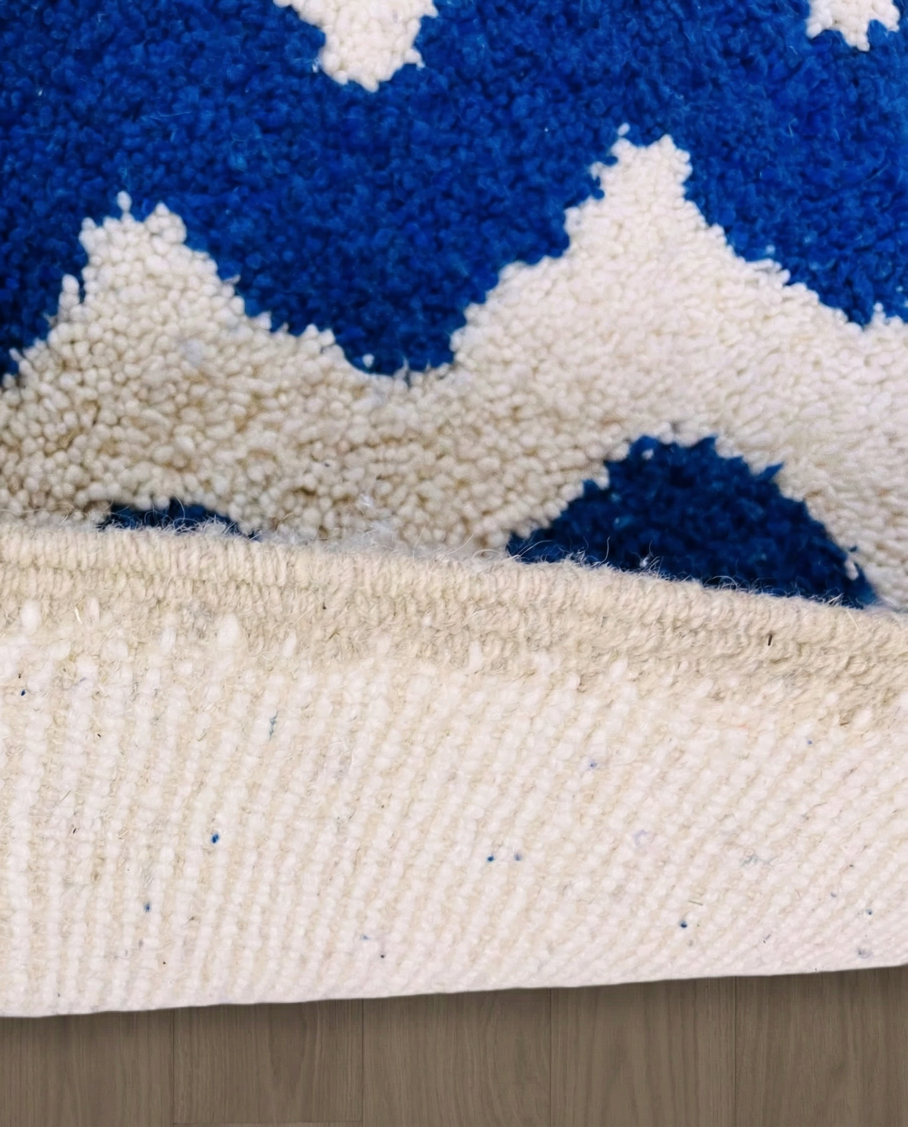 SOUMIA Beni Ourain cobalt wavy striped field Moroccan rug close-up showing hand-knotted wool texture and pile detail 2, by NURA