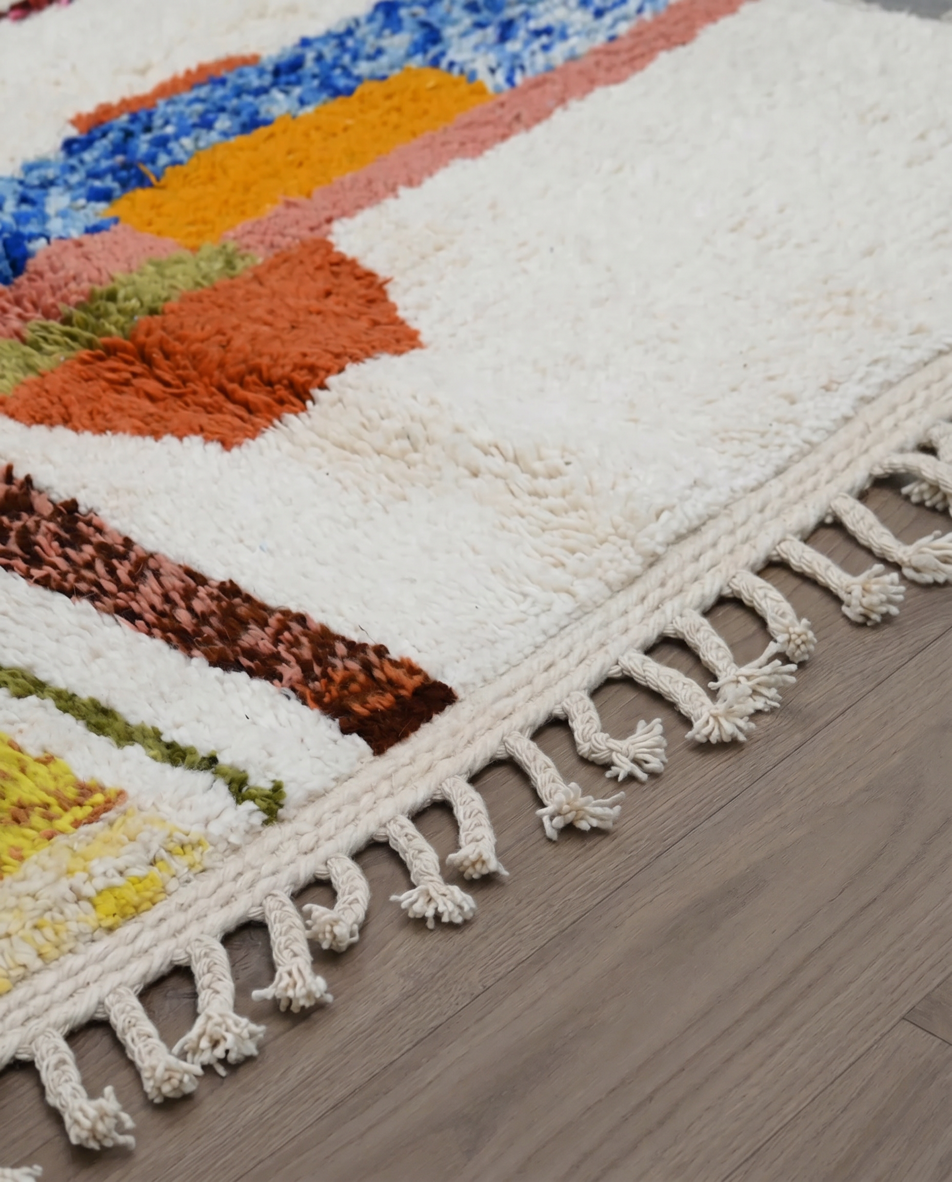 STERA Azilal cream abstract color block Moroccan rug close-up of hand-tied fringe and kilim band detail, by NURA