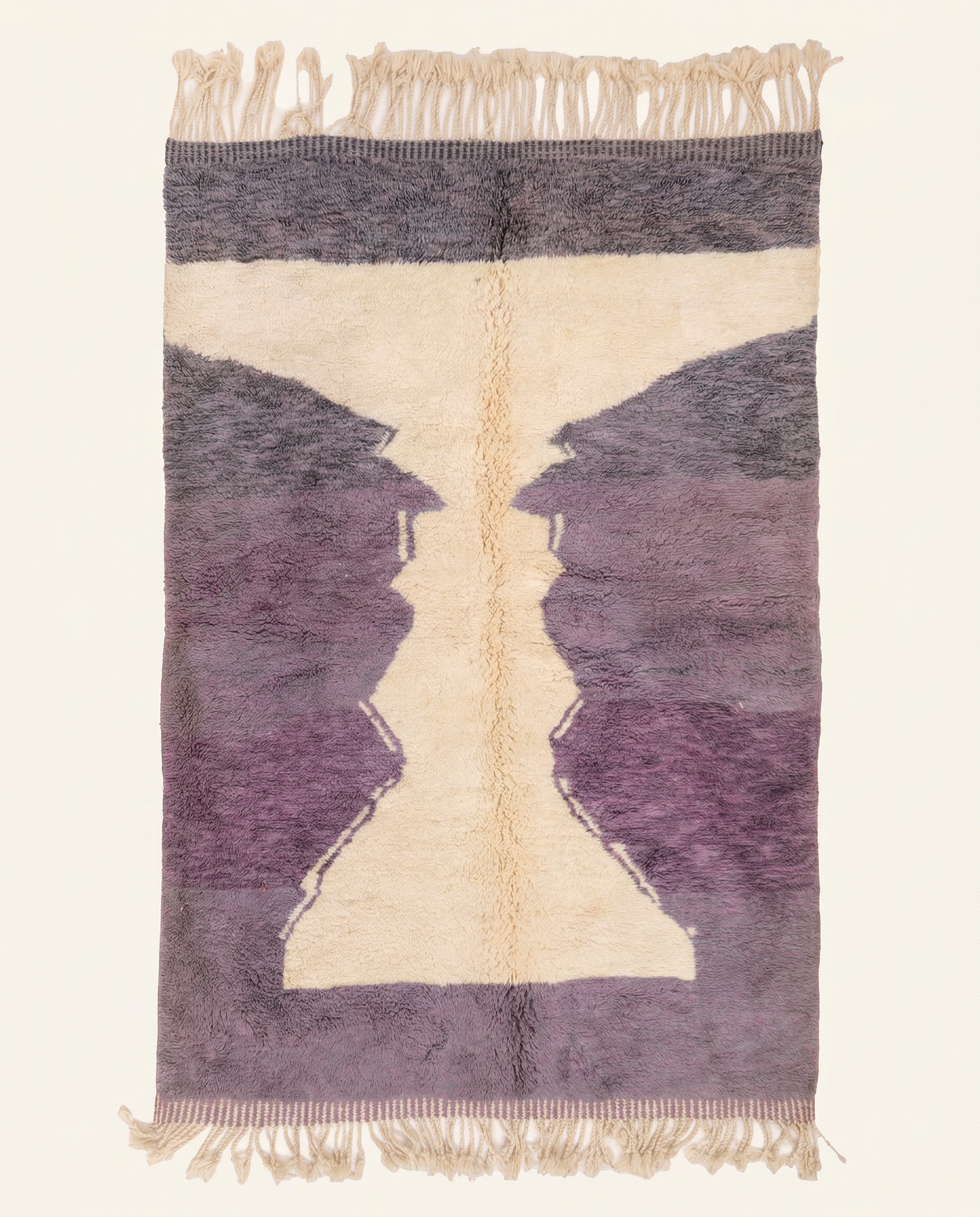 Plush plum purple Boujad Moroccan rug with a bold cream abstract hourglass motif and dense hand-knotted high pile, by NURA.