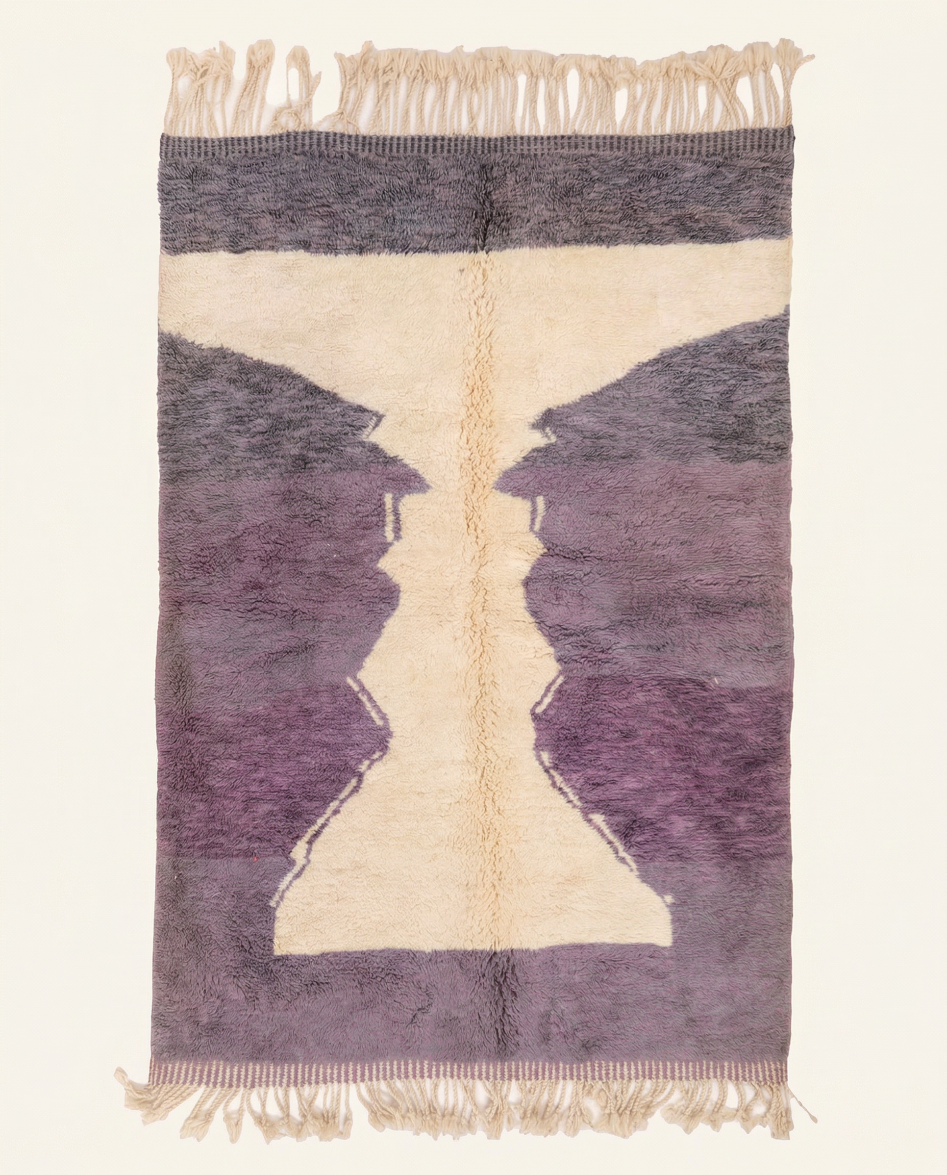Plush plum purple Boujad Moroccan rug with a bold cream abstract hourglass motif and dense hand-knotted high pile, by NURA.