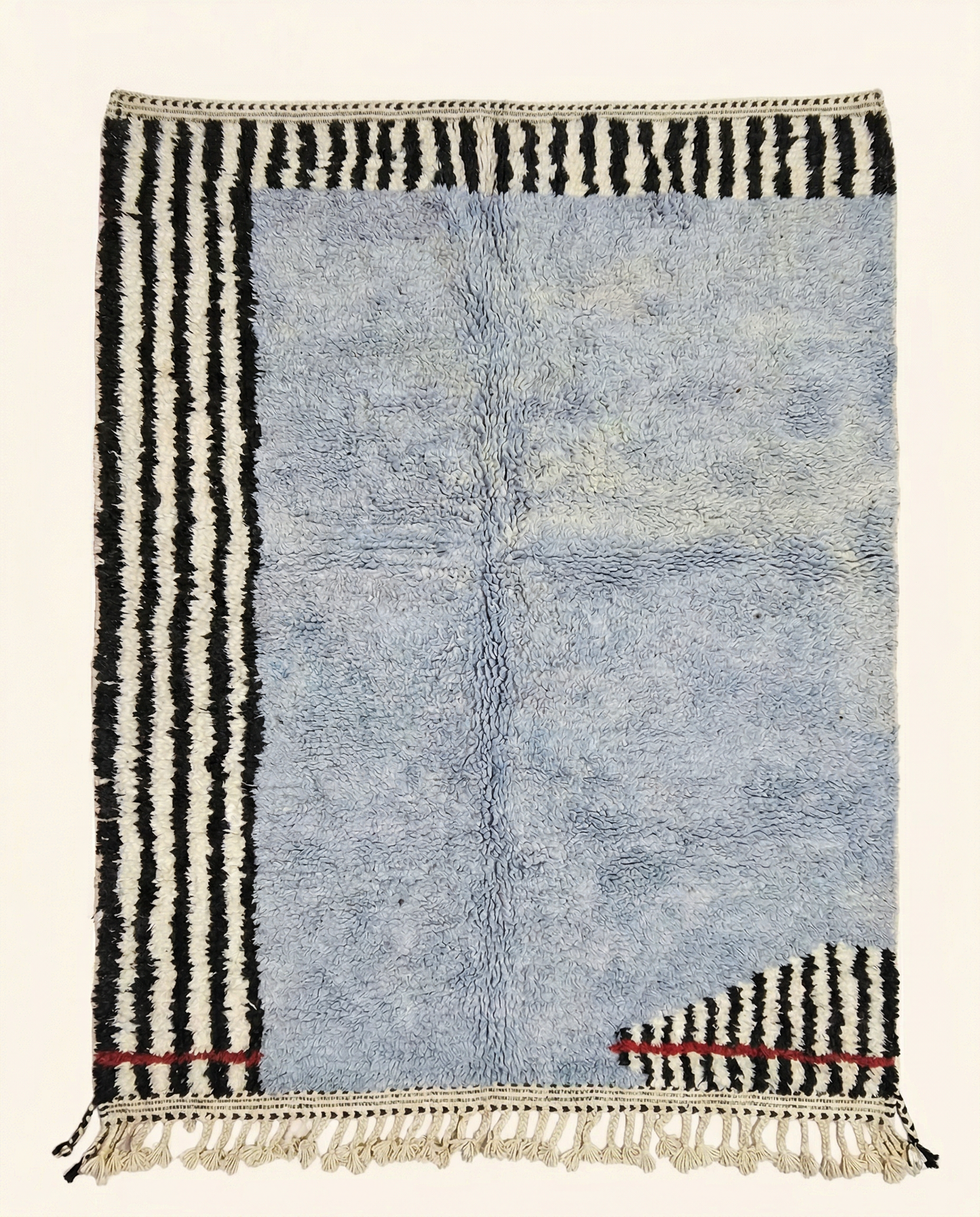 Plush powder blue Azilal Moroccan rug with bold asymmetrical black and white stripes and a red accent line, by NURA.