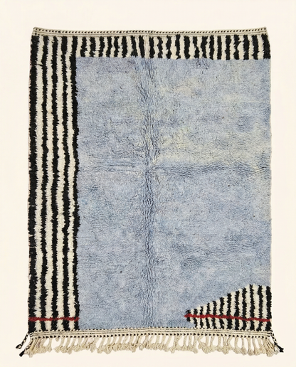 Plush powder blue Azilal Moroccan rug with bold asymmetrical black and white stripes and a red accent line, by NURA.
