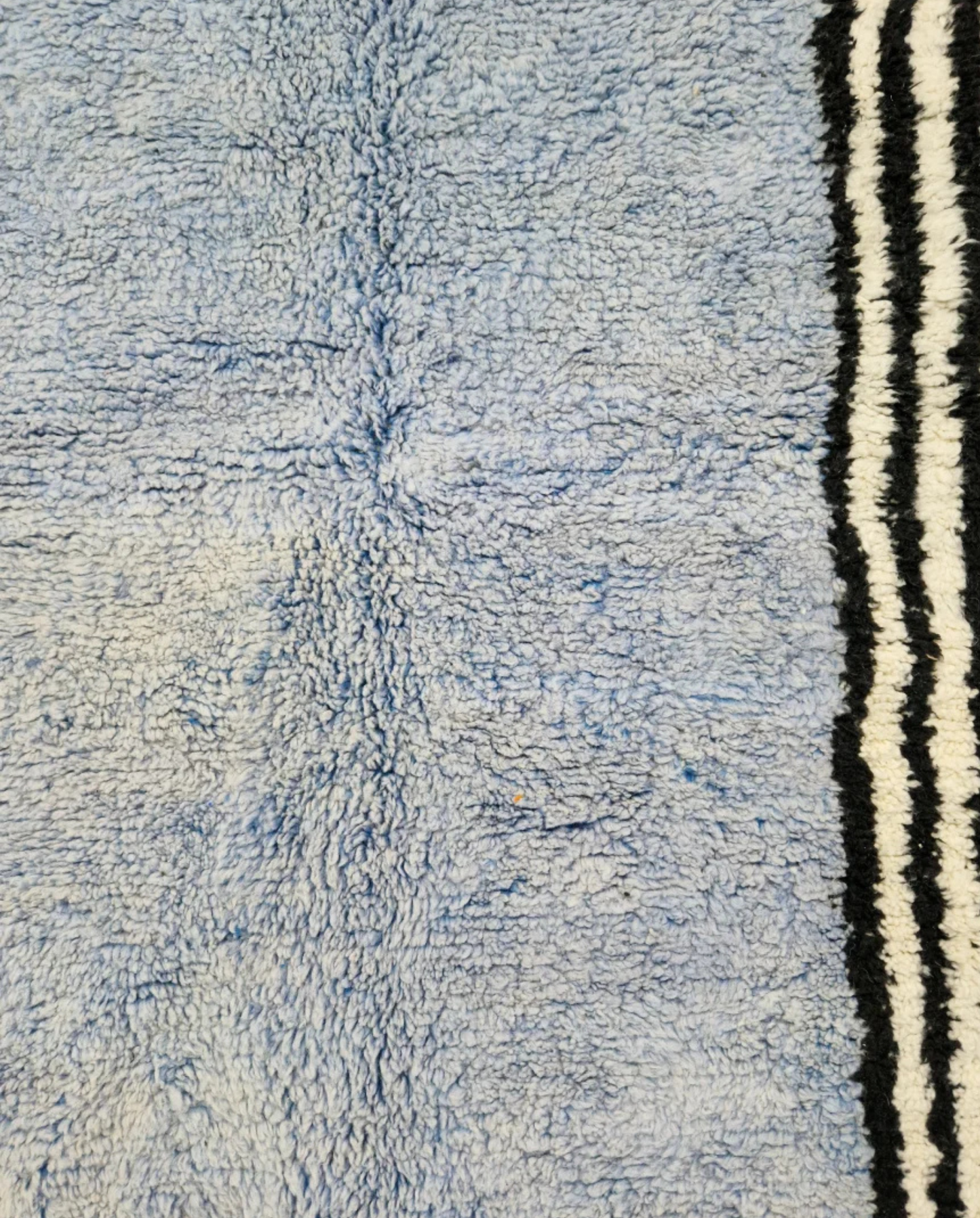 YASMINE Azilal powder blue asymmetrical striped border Moroccan rug close-up showing hand-knotted wool texture and pile detail, by NURA