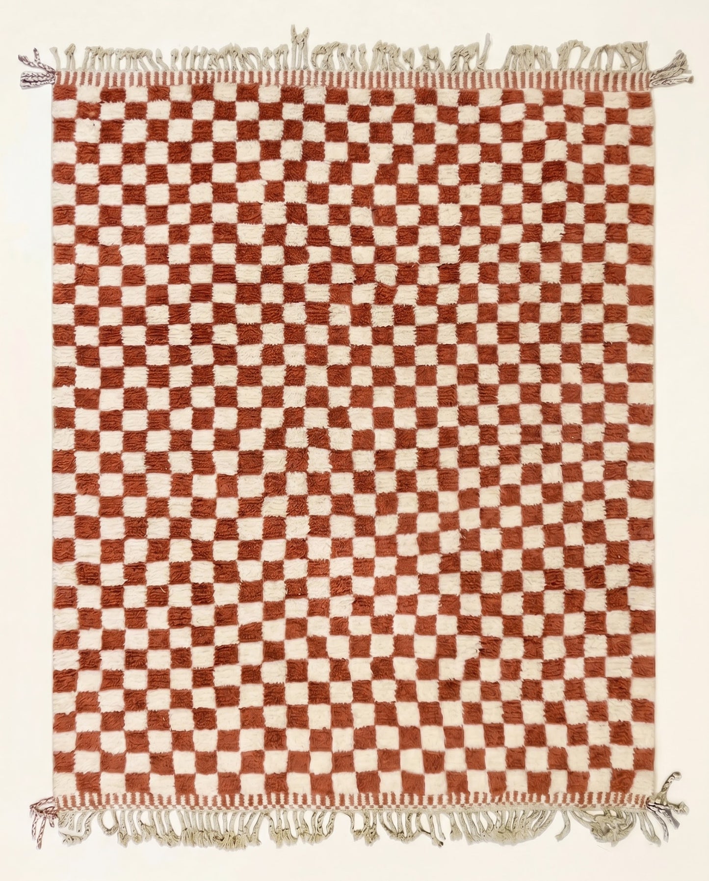 A plush Beni Ourain Moroccan rug by NURA featuring a classic checkerboard pattern in warm terracotta and natural cream wool.