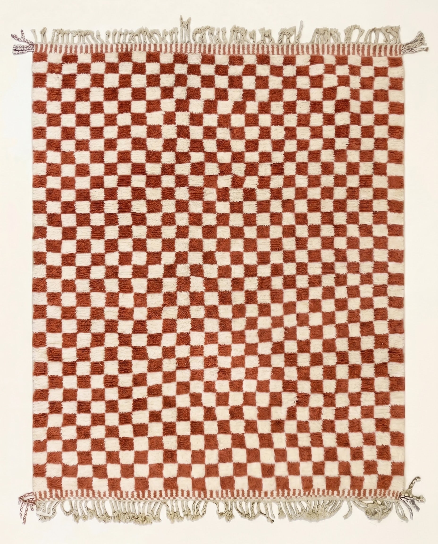 A plush Beni Ourain Moroccan rug by NURA featuring a classic checkerboard pattern in warm terracotta and natural cream wool.