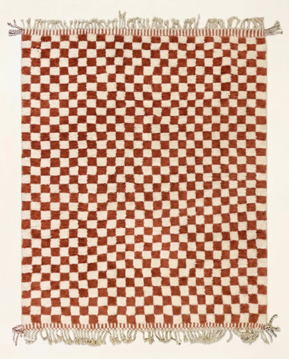 A plush Beni Ourain Moroccan rug by NURA featuring a classic checkerboard pattern in warm terracotta and natural cream wool.