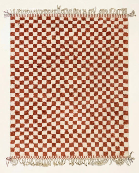 A plush Beni Ourain Moroccan rug by NURA featuring a classic checkerboard pattern in warm terracotta and natural cream wool.