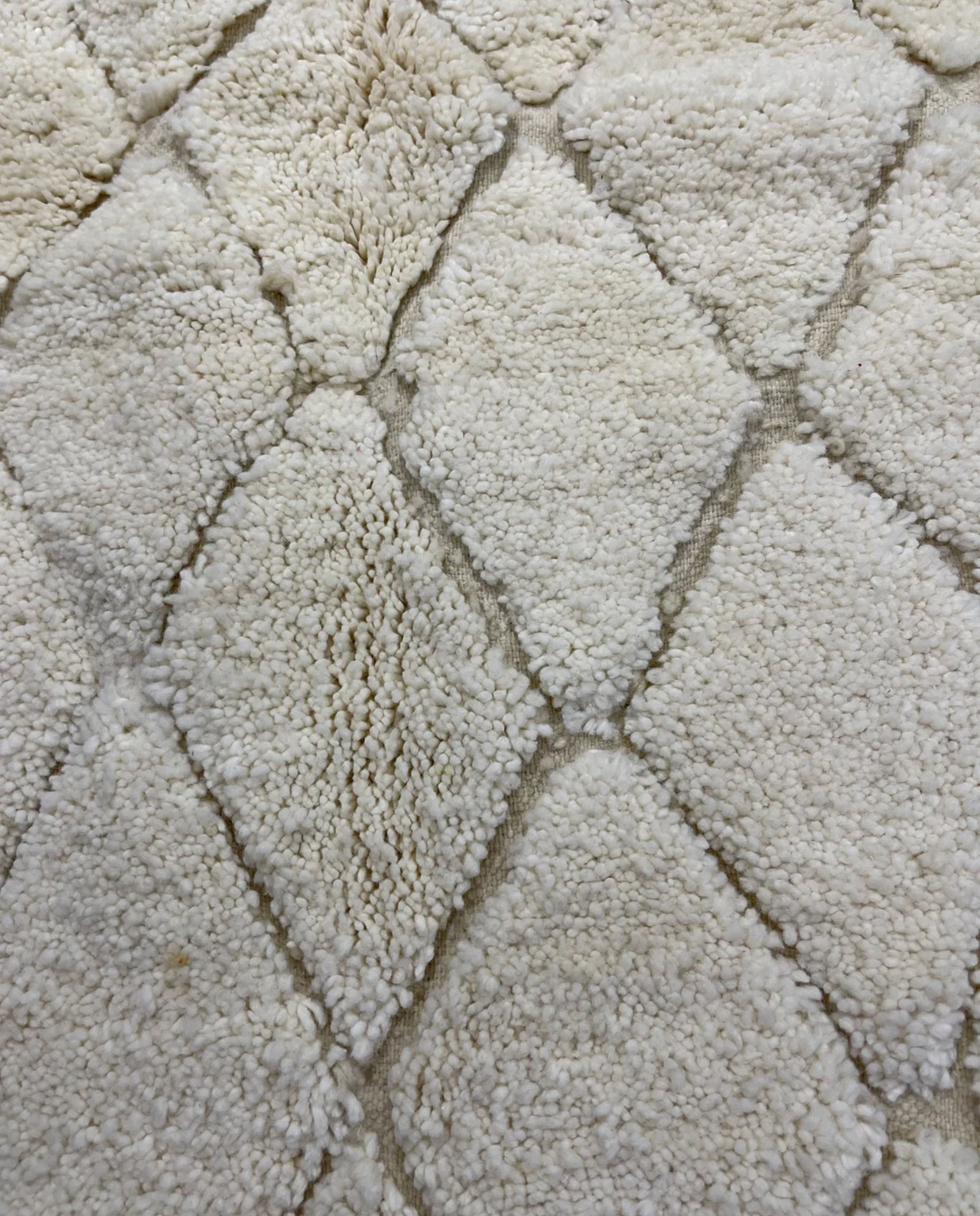 ZAKIA Beni Ourain ivory diamond lattice Moroccan rug close-up showing hand-knotted wool texture and pile detail, by NURA