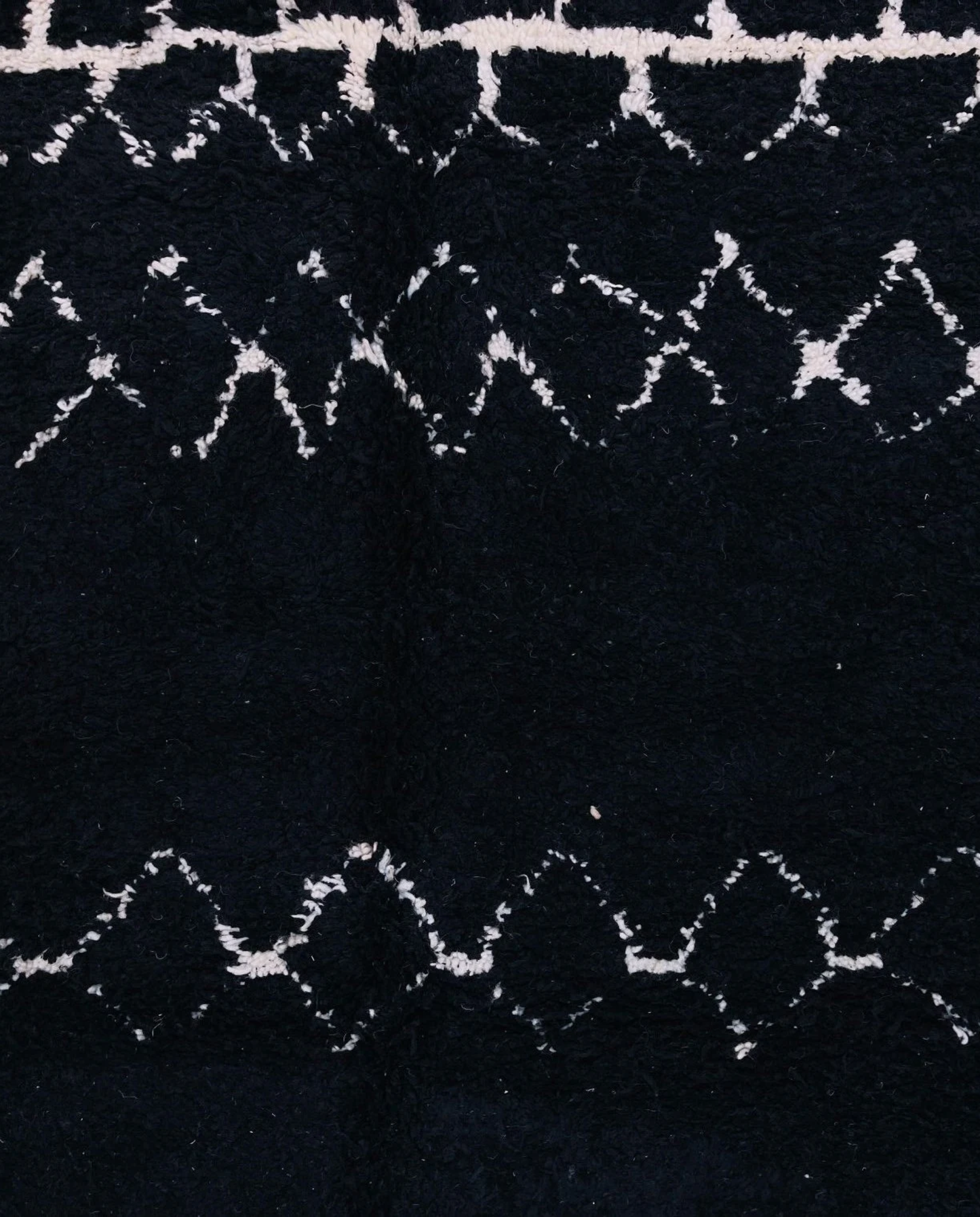 ZOHRA Beni Ourain black horizontal geometric bands Moroccan rug close-up showing hand-knotted wool texture and pile detail 1, by NURA