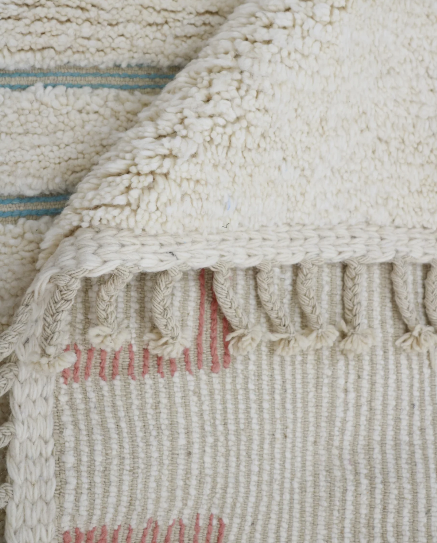 ZOUBIDA Beni Ourain cream floating forms Moroccan rug close-up of hand-tied fringe and kilim band detail, by NURA