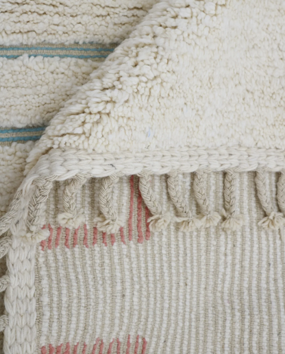 ZOUBIDA Beni Ourain cream floating forms Moroccan rug close-up of hand-tied fringe and kilim band detail, by NURA